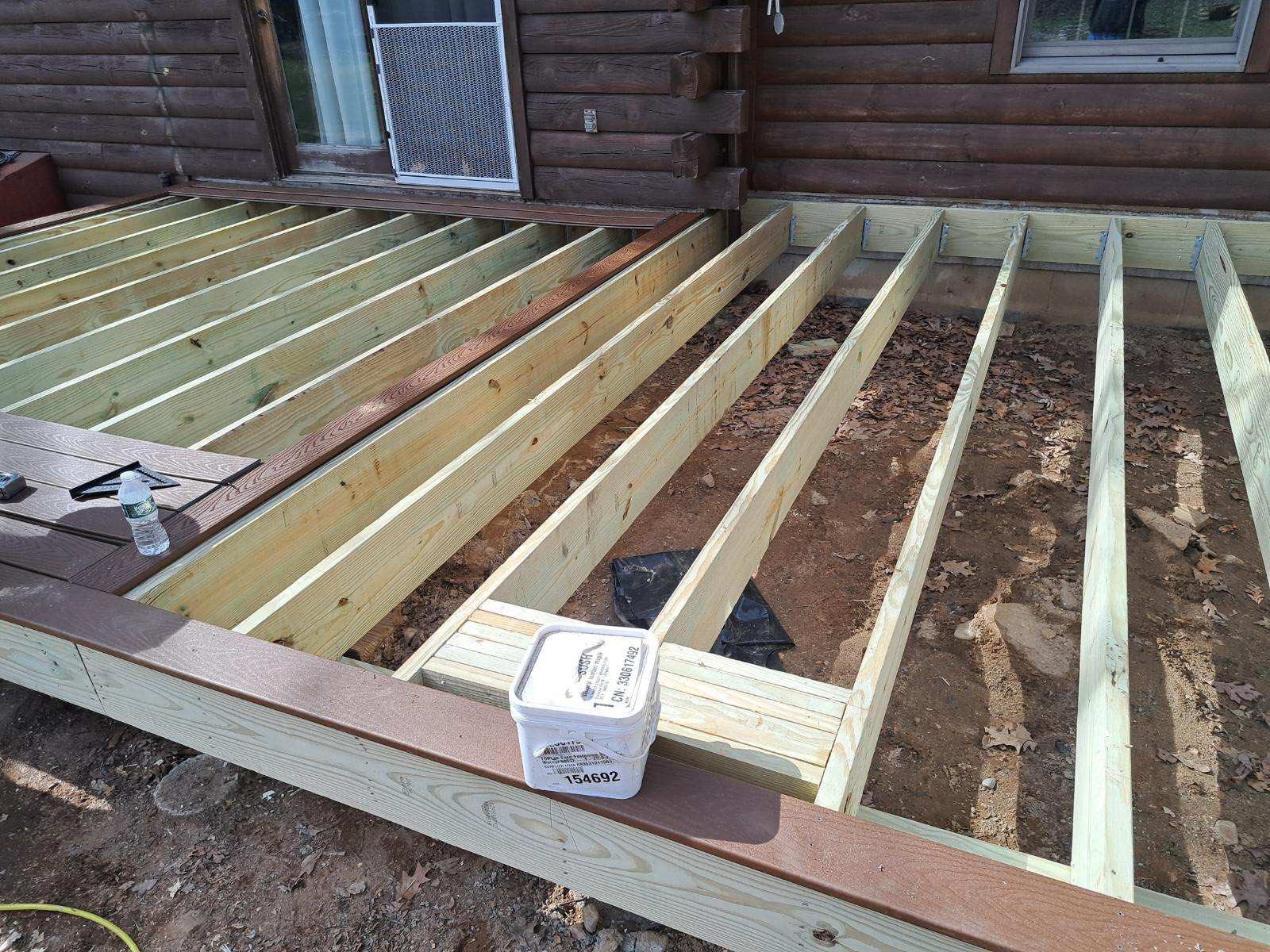 In-progress home remodeling showing pressure-treated wood framing and composite decking installation at a log cabin home in Andover, CT project by Lagace Construction.