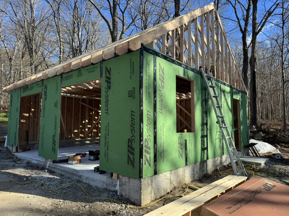 Garage under construction in Hebron CT with ZIP System sheathing, exposed framing, and concrete foundation for a new two car garage build by Lagace Construction.
